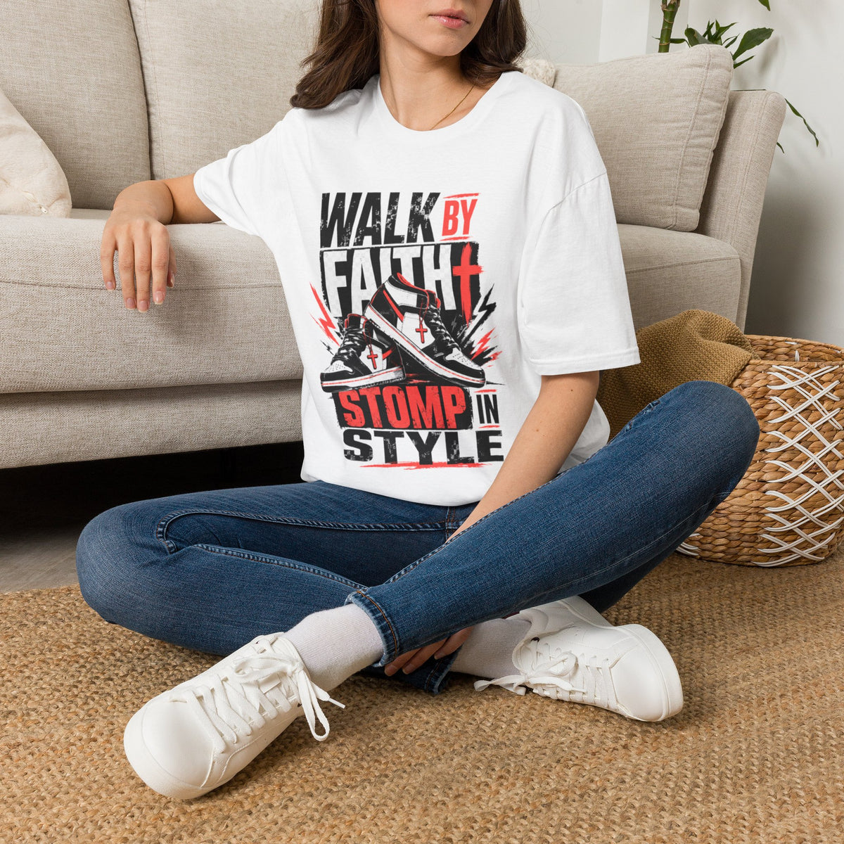 Person wearing a white t-shirt with a graphic design sitting on a couch.